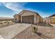 View of house with desert landscaping, two car garage, and light colored brick driveway at 25308 N 133Rd Ave, Peoria, AZ 85383
