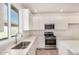 Bright kitchen features white cabinets, stainless steel appliances, quartz counters, and modern fixtures at 25308 N 133Rd Ave, Peoria, AZ 85383