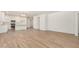 View of a living space with wood-look tile flooring leading to an open kitchen and other rooms at 25308 N 133Rd Ave, Peoria, AZ 85383