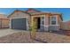 Charming single-story home featuring a gray garage door and low-maintenance desert landscaping at 25314 N 133Rd Ave, Peoria, AZ 85383