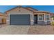Charming home showcasing a spacious gray garage door and desert landscaping at 25314 N 133Rd Ave, Peoria, AZ 85383