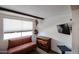 Cozy bedroom with a comfortable seating area, wooden accents and a wall-mounted TV at 2605 W Rose Ln # B-202, Phoenix, AZ 85017