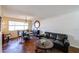 Bright living room with unique concrete floors, comfortable seating, and a round decorative mirror at 2605 W Rose Ln # B-202, Phoenix, AZ 85017