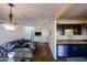 Open-concept living room and kitchen featuring dark cabinets, granite countertops, and comfortable seating at 2605 W Rose Ln # B-202, Phoenix, AZ 85017