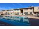 Community pool with clear blue water, surrounded by a secure fence and well-maintained building exteriors at 2605 W Rose Ln # B-202, Phoenix, AZ 85017