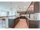 Modern kitchen with stainless steel appliances, granite countertops, and dark wood cabinets providing ample storage at 277 W Glacier Bay Dr, San Tan Valley, AZ 85140