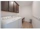 Functional laundry room with modern washer and dryer, and ample storage cabinets for supplies at 277 W Glacier Bay Dr, San Tan Valley, AZ 85140