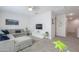 Bright living room with a gray sofa, carpet flooring, ceiling fan, and a decorative accent wall art at 277 W Glacier Bay Dr, San Tan Valley, AZ 85140