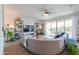 Spacious living room featuring a curved sofa, tile flooring, and sliding glass doors leading to the backyard at 277 W Glacier Bay Dr, San Tan Valley, AZ 85140