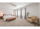 Elegant bedroom featuring neutral colors, ample natural light, and cozy seating area at 277 W Glacier Bay Dr, San Tan Valley, AZ 85140
