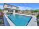 A pristine pool with a safety fence with shaded lounge chairs, and desert landscaping at 277 W Glacier Bay Dr, San Tan Valley, AZ 85140