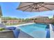 Sparkling pool surrounded by an iron fence and lush landscaping on the other side of the yard at 277 W Glacier Bay Dr, San Tan Valley, AZ 85140