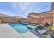 Relaxing backyard pool with sunshade, and lounge chairs, surrounded by privacy walls and desert landscaping at 277 W Glacier Bay Dr, San Tan Valley, AZ 85140