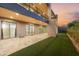 Modern home featuring a travertine patio, lawn, and sliding glass doors offering seamless indoor/outdoor living at 29599 N 106Th Pl, Scottsdale, AZ 85262