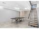 Spacious basement with a ping pong table and staircase leading to upper floor at 29599 N 106Th Pl, Scottsdale, AZ 85262
