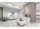 Bright bathroom featuring a soaking tub next to a modern fireplace, vanity with a round mirror, and sitting area at 29599 N 106Th Pl, Scottsdale, AZ 85262