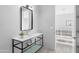 Modern bathroom features sleek vanity with open metal frame, contemporary mirror, and access to an open tiled space at 29599 N 106Th Pl, Scottsdale, AZ 85262
