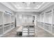 Spacious walk-in closet featuring custom shelving and drawers, center island, bench seating, and modern chandelier at 29599 N 106Th Pl, Scottsdale, AZ 85262