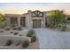 Modern home featuring desert landscaping, a stone driveway, and a three car garage at 29599 N 106Th Pl, Scottsdale, AZ 85262