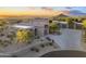 Contemporary home with desert landscaping, mountain views, and a spacious driveway at sunset at 29599 N 106Th Pl, Scottsdale, AZ 85262