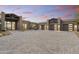 Stunning desert home with desert landscaping, a paved driveway, and a spacious three-car garage at dusk at 29599 N 106Th Pl, Scottsdale, AZ 85262