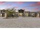 Charming single-story home with stone driveway, desert landscaping, and modern design set against a sunset sky at 29599 N 106Th Pl, Scottsdale, AZ 85262