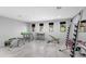 Well-lit home gym featuring exercise equipment, light gray walls, tile floors, and outdoor views from three windows at 29599 N 106Th Pl, Scottsdale, AZ 85262