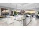 An open kitchen is equipped with stainless steel appliances, marble countertops, and sleek white cabinetry at 29599 N 106Th Pl, Scottsdale, AZ 85262
