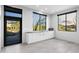 Bright kitchenette with white cabinets, granite countertops, large windows showcasing desert views and a doorway at 29599 N 106Th Pl, Scottsdale, AZ 85262