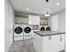 Spacious laundry room features modern appliances, folding table with marble countertop, and storage at 29599 N 106Th Pl, Scottsdale, AZ 85262