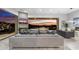 Elegant living room featuring fireplace, flat-screen TV and open access to an outdoor patio with sunset views at 29599 N 106Th Pl, Scottsdale, AZ 85262