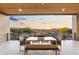 Covered patio with mountain and sunset views featuring a dining table and comfortable seating at 29599 N 106Th Pl, Scottsdale, AZ 85262