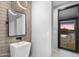 Contemporary powder room featuring a vessel sink, black framed mirror, and brick accent wall at 29599 N 106Th Pl, Scottsdale, AZ 85262
