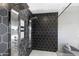 Modern walk-in shower with black hexagon tile surround and multiple shower heads and stainless steel hardware at 29599 N 106Th Pl, Scottsdale, AZ 85262