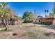 Spacious backyard with mature trees, a play structure and a covered patio at 304 W 6Th St, Mesa, AZ 85201