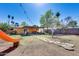 Large backyard with a patio, lawn, mature trees, walking path, and a playground slide at 304 W 6Th St, Mesa, AZ 85201