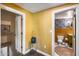 Hallway leading to stylish half-bathroom with floral wallpaper and a patterned rug at 304 W 6Th St, Mesa, AZ 85201