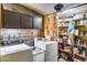 Functional laundry room with washer, dryer, storage shelves, and wood paneling for rustic charm at 304 W 6Th St, Mesa, AZ 85201