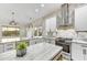 Bright, stylish kitchen with stainless appliances, white cabinets, marbled countertops, and contemporary lighting fixtures at 32806 N 55Th Pl, Cave Creek, AZ 85331