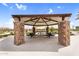 Community pavilion with stone pillars, picnic tables, and a metal roof providing shade on a sunny day at 3309 E Malibu Dr, San Tan Valley, AZ 85143