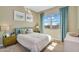 This is a bright bedroom features soft bedding, neutral paint, a large window, and natural light, creating a calm and inviting space at 3347 E Malibu Dr, San Tan Valley, AZ 85143