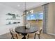 Modern dining room featuring a round table, stylish light fixture and decorated floating shelves at 3347 E Malibu Dr, San Tan Valley, AZ 85143