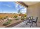 Comfortable patio with table and chairs overlooking the landscaped backyard with rocks and desert plants at 3347 E Malibu Dr, San Tan Valley, AZ 85143