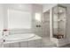 Spa-like bathroom featuring a soaking tub, walk-in shower, and modern tile design at 3522 E Penedes Dr, Gilbert, AZ 85298