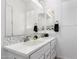 Bathroom with a double sink vanity with modern fixtures, white cabinets and a bright mirror at 3522 E Penedes Dr, Gilbert, AZ 85298