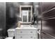 Stylish powder room with a modern vanity, black textured walls, and unique decor at 3522 E Penedes Dr, Gilbert, AZ 85298