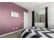Bedroom with a bed and a window, featuring a purple accent wall, gray carpet and white door at 3522 E Penedes Dr, Gilbert, AZ 85298