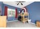bedroom with a bunk bed, window, gray carpet, and blue walls with Captain America themed art at 3522 E Penedes Dr, Gilbert, AZ 85298