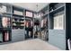 Spacious walk-in closet with custom blue cabinetry and shelving and chandelier lighting, offering ample storage at 3522 E Penedes Dr, Gilbert, AZ 85298