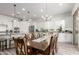 Open-concept dining room featuring modern light fixtures, an island with barstool seating, and wood-look tile floors at 3522 E Penedes Dr, Gilbert, AZ 85298